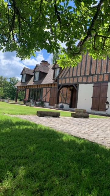 un grand bâtiment marron avec une cour herbeuse devant dans l'établissement Propriété 12 personnes en Sologne, à La Ferté-Imbault