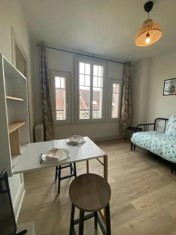 un salon avec une table et un lit dans l'établissement Appartement charmant à Vichy, cosy, 23 m², près des thermes, à Vichy