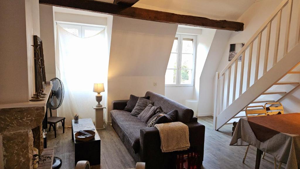 un salon avec un canapé et un escalier dans l'établissement Au calme en vieille ville - Proche lac - Ambiance esprit brocante, à Annecy