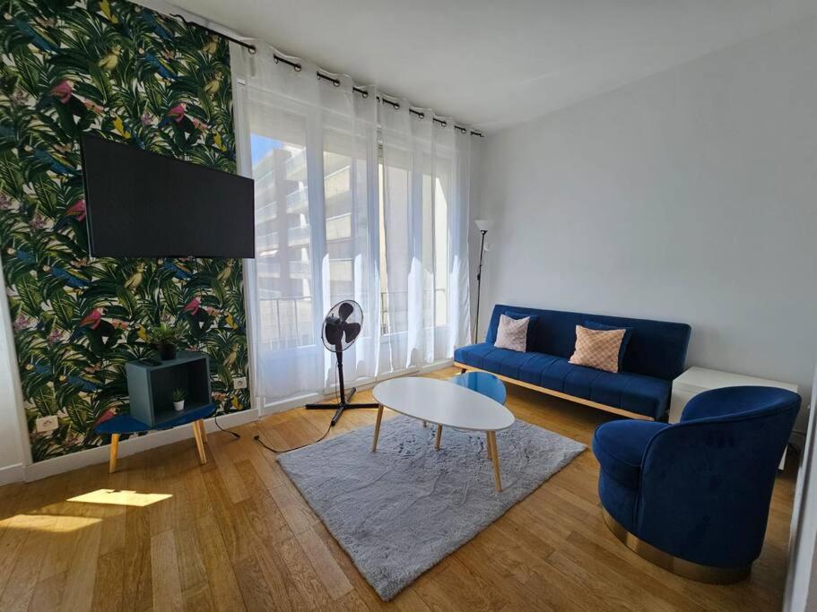 un salon avec un canapé bleu et une table dans l'établissement Studio moderne et lumineux, proche Tete d Or, Lyon, à Lyon