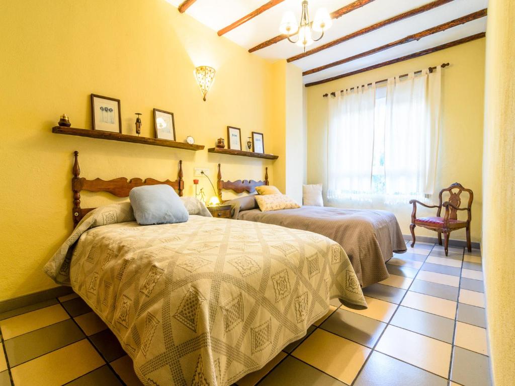 1 dormitorio con 2 camas y ventana en Lanjarón Rural Apartamentos, en Lanjarón