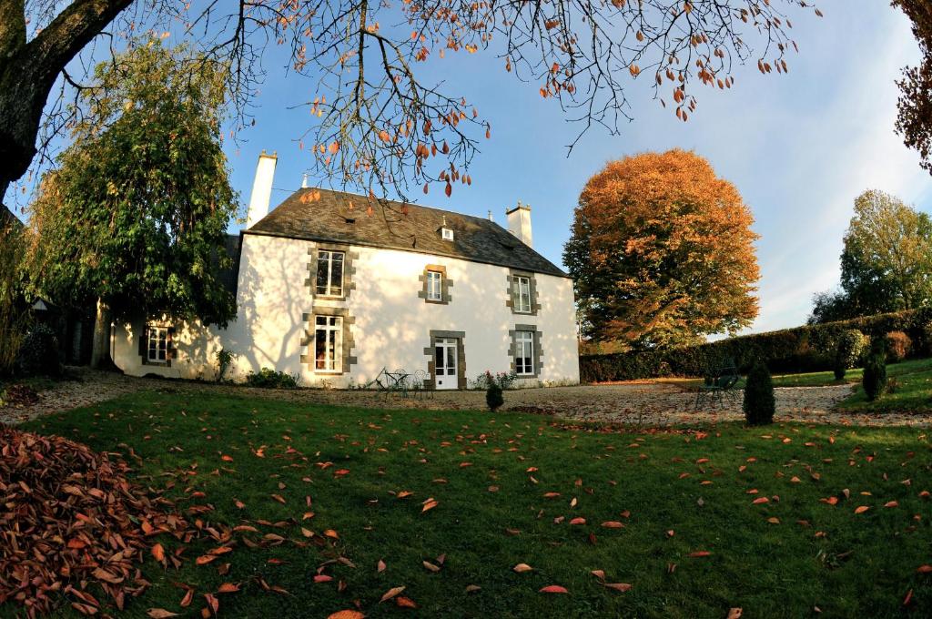 une vieille maison blanche sur une pelouse dans l'établissement Logis de Vaux - Maison de campagne familiale spacieuse, à Madré