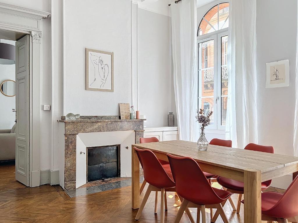 une salle à manger avec une table et une cheminée dans l'établissement Le Saint Antoine, à Toulouse