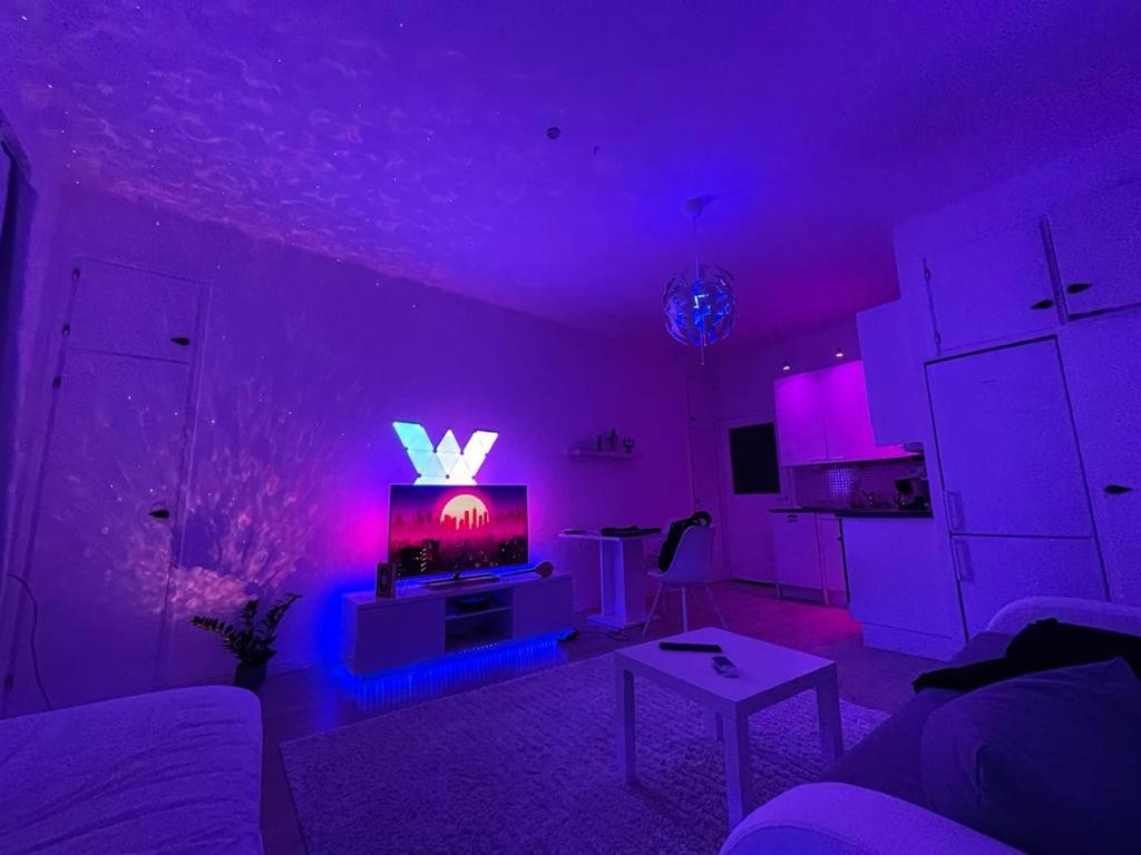a purple living room with a tv and a table at Smart 32m2 studio in a central location - Kallio in Helsinki