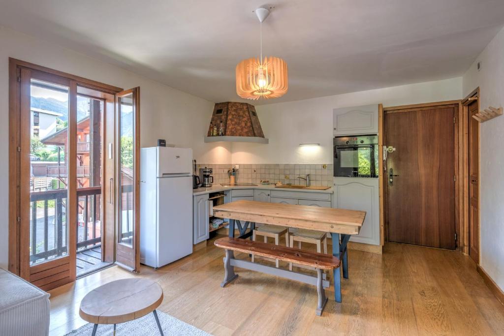 une cuisine avec une table en bois et un réfrigérateur dans l'établissement Duplex de Miage - Welkeys, à Saint-Gervais-les-Bains
