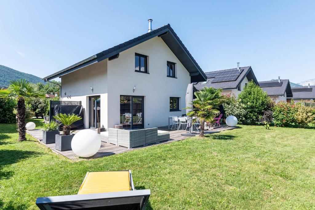 une maison blanche avec une arrière-cour et une pelouse dans l'établissement Maison neuve proche lac d'Annecy, à Saint-Jorioz