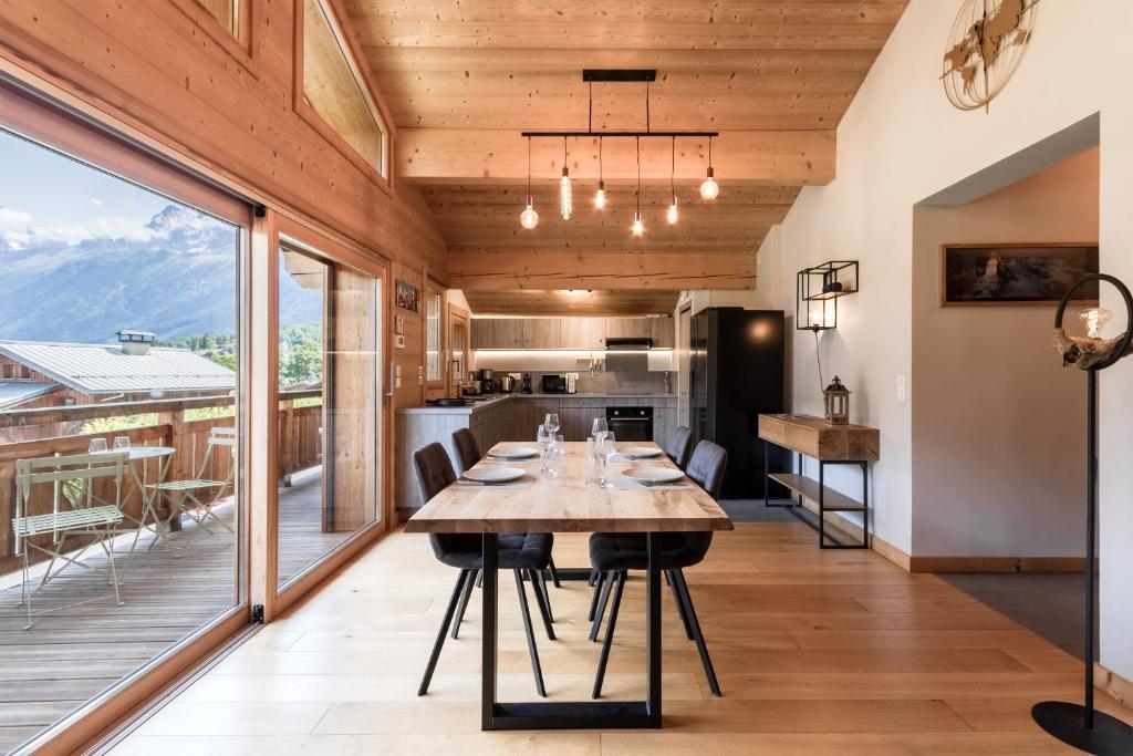 ein Esszimmer mit einem Tisch und einem großen Fenster in der Unterkunft Les Trabets - Bellevue telecabine - Renove in Les Houches
