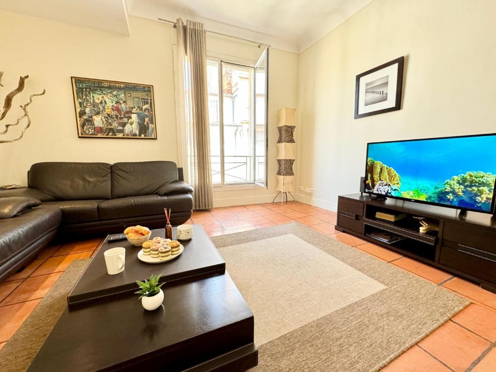 un salon avec un canapé et une télévision à écran plat dans l'établissement Grand Palais 4P BOB1309, à Cannes