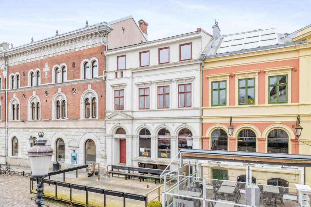 a group of buildings with benches in front of them at One room apartment the Square in Ystad