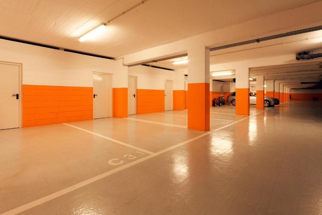 an empty parking garage with orange and white walls at Troia Residence by The Editory - Apartamentos Marina in Troia