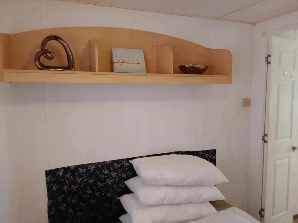 ein Stapel weißer Kissen auf einem Regal in der Unterkunft Arizona Caravan in Camber