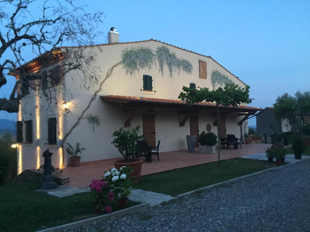 a large white house with a lot of plants at Casale Olea in Massarosa