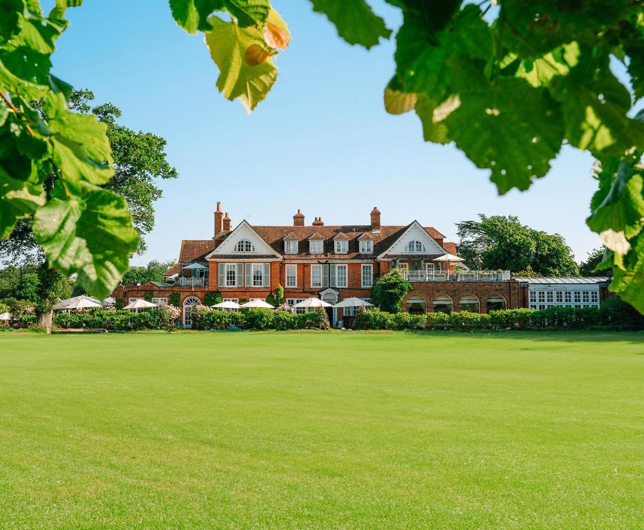 a large house with a green field in front of it at Chewton Glen Hotel - an Iconic Luxury Hotel in New Milton