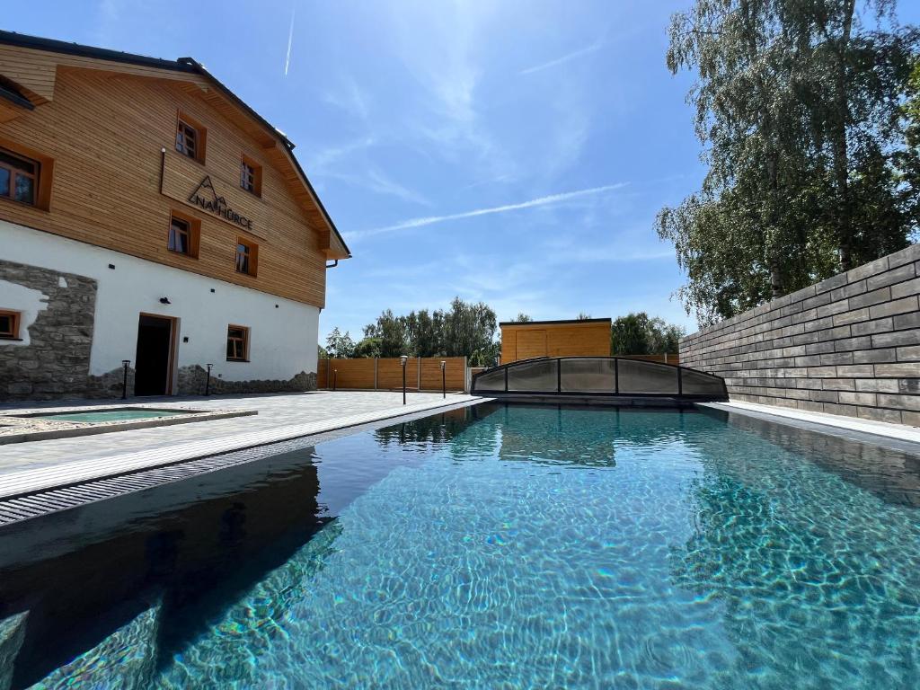 a swimming pool in front of a building at Apartmán Manuel in Horní Planá