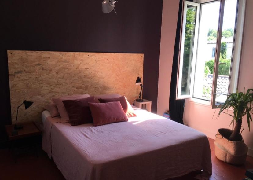 - une chambre avec un grand lit et des oreillers violets dans l'établissement Maison avec jardin proche plages Marseille, à Marseille