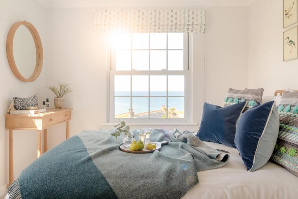 a bedroom with a bed with a plate of fruit on it at Sandpipers, Port Isaac Bay Holidays in Port Isaac