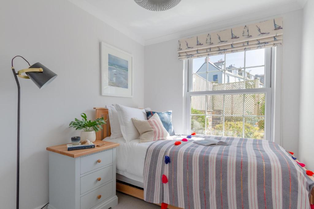a bedroom with a bed and a window at Sandpipers, Port Isaac Bay Holidays in Port Isaac