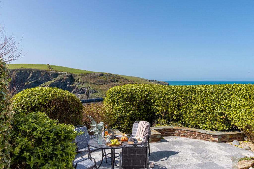 a patio with a table and chairs and the ocean at Sandpipers, Port Isaac Bay Holidays in Port Isaac