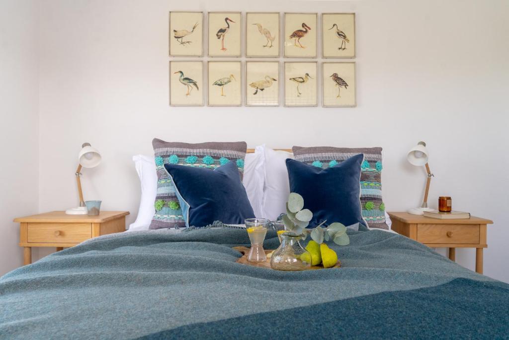 a bed with a blue blanket with fruit on it at Sandpipers, Port Isaac Bay Holidays in Port Isaac