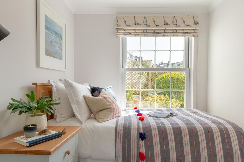 a bedroom with a bed and a window at Sandpipers, Port Isaac Bay Holidays in Port Isaac