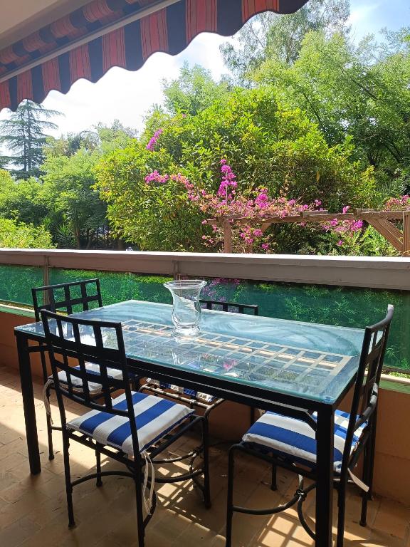 - une table en verre et 2 chaises sur une terrasse couverte dans l'établissement Confortable T2 Hyères, à Hyères