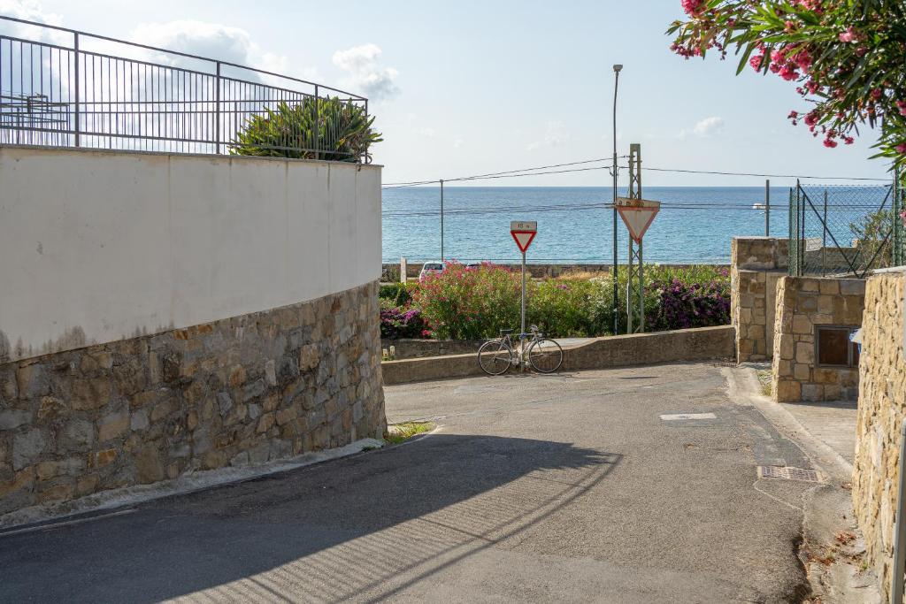 a bike parked next to a stone wall next to the ocean at E&J Mare e Relax in Sanremo