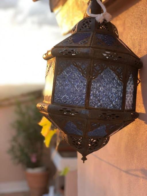 une lanterne noire suspendue sur le côté d'un bâtiment dans l'établissement Superbe maison de village et sa terrasse panoramique, à Oupia