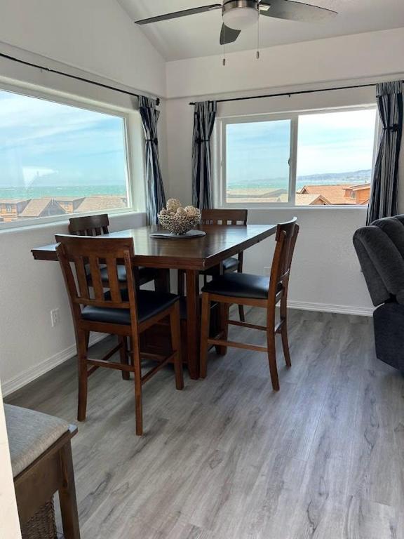 Smith RiverにあるOceanview Cabin 20, Private Jacuzzi &large Deckのダイニングルーム(テーブル、椅子、窓2つ付)