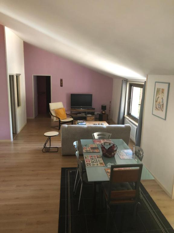 un salon avec un canapé et une table dans l'établissement Charmant logement, à Saint-Amand-de-Vergt