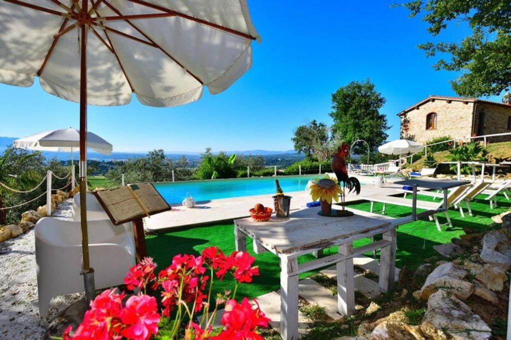 a patio with a table and an umbrella and a pool at Villa Dallara in Rignano sullʼArno