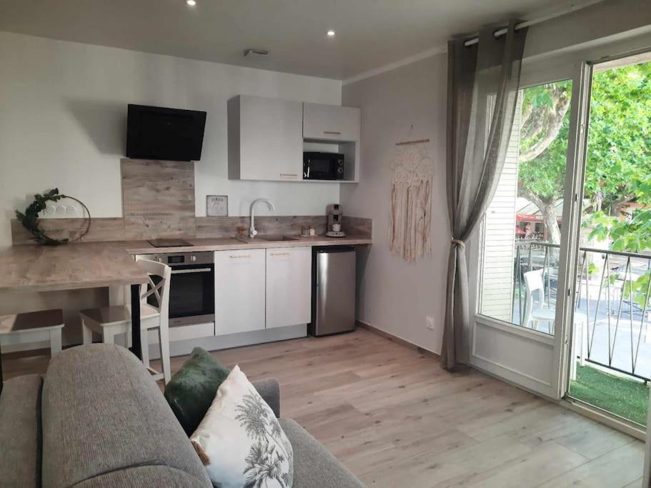 un salon avec un canapé et une cuisine dans l'établissement Studio 4 - Appart'hôtel avec balcon - TU ELLETA, à Tulette