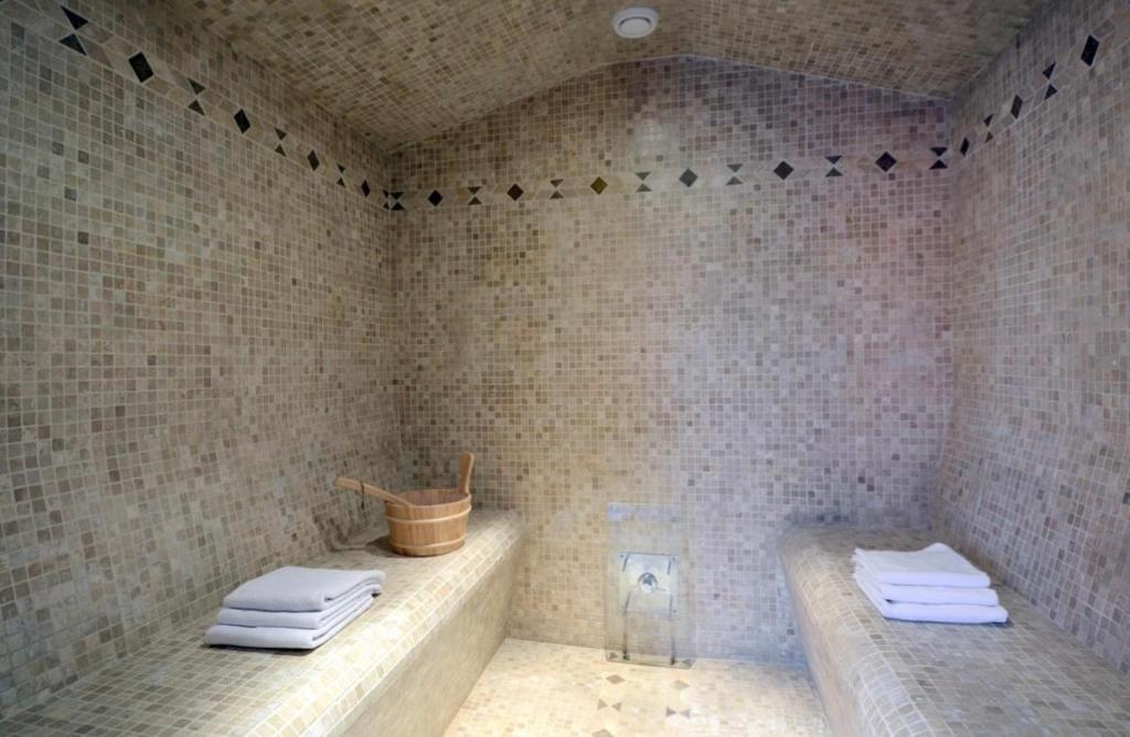 une salle de bain carrelée avec baignoire et serviettes dans l'établissement Studio meublé, à Saint-Jean-de-Védas