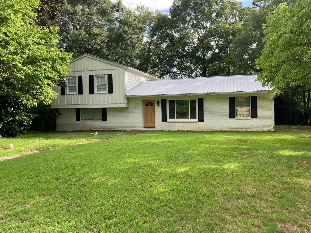 a small white house with a grass yard at 4 Bedroom Furnished Private Home Near UGA Downtown Athens in Athens