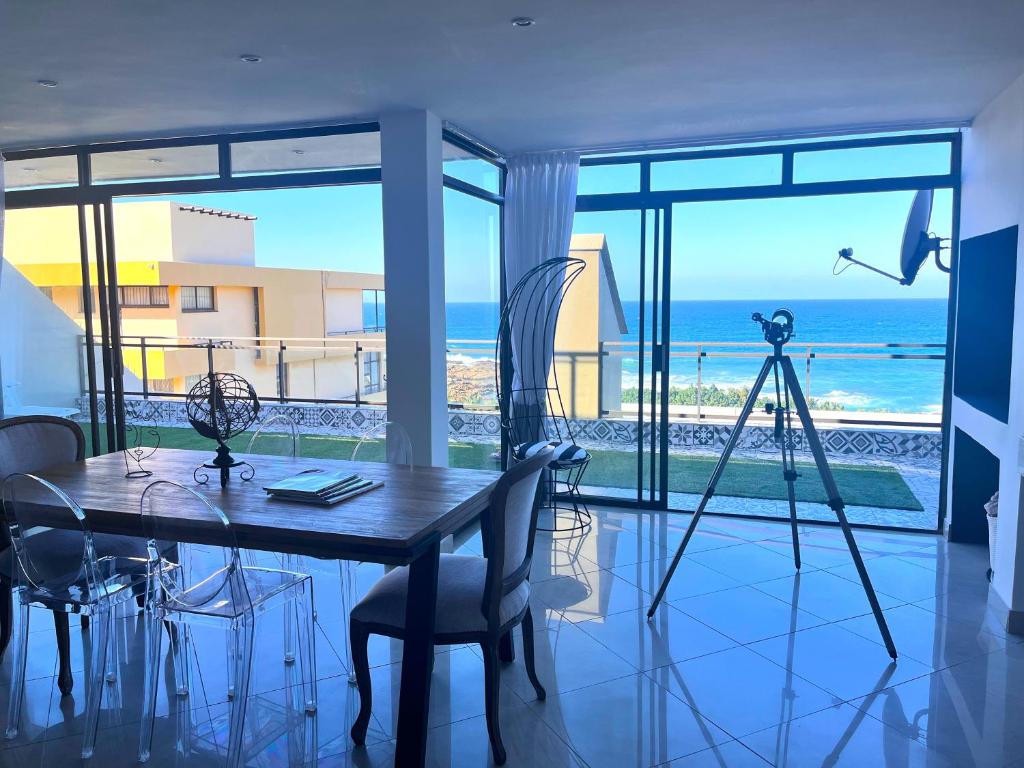 Un comedor con mesa y vista al mar. en Simla Luxury Apartments 11, en Margate