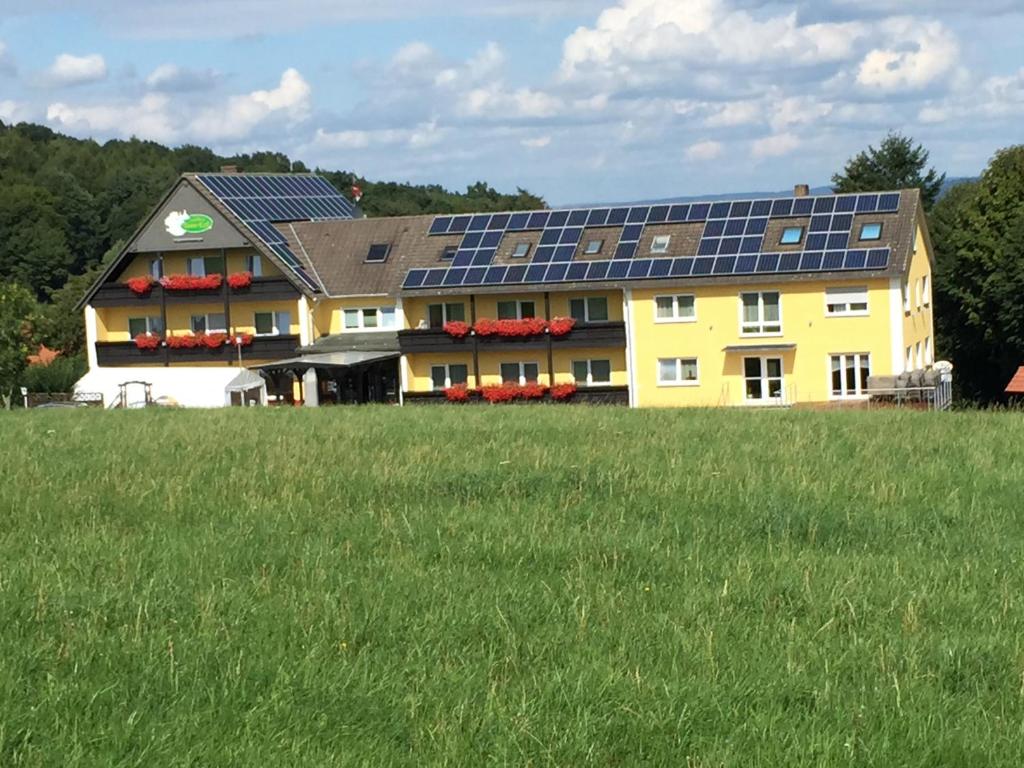a large yellow building with solar panels on it at Knüllhotel Tann-Eck in Knüllwald