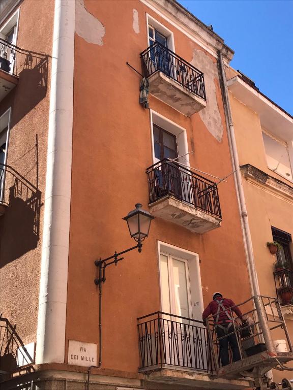 dwie osoby stojące na balkonie budynku w obiekcie casa SorrisiEsoGni w Cagliari