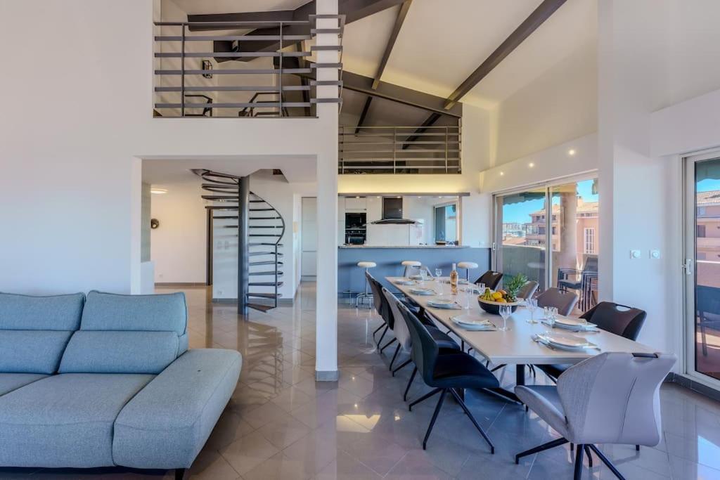 - une salle à manger avec une grande table et un canapé dans l'établissement Duplex front de mer, à Fréjus