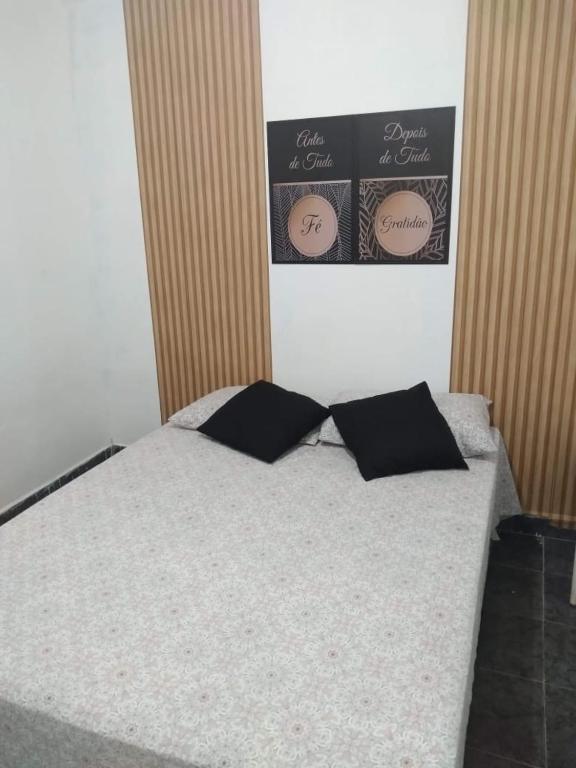 a bedroom with a bed with two pillows on it at Hostel da Maisa Quarto casal com ar condicionado e banheiro compartilhado in Barreiras