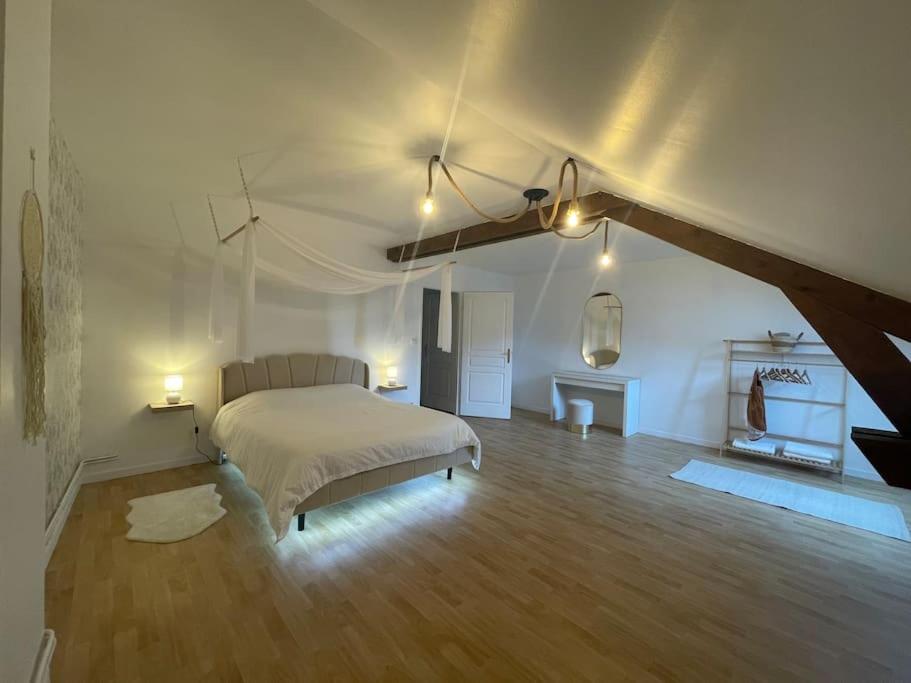 un dormitorio con una cama grande en una habitación en Le Triangle d Or, en Langres