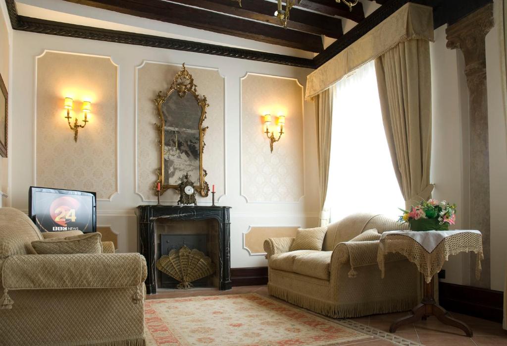 Appartamento Ca' Cavalli في البندقية: غرفة معيشة مع أريكة ومدفأة