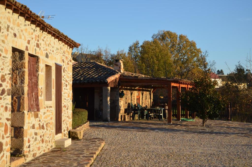 a stone house with a table and a patio at Casa do Manego in Quadrazais