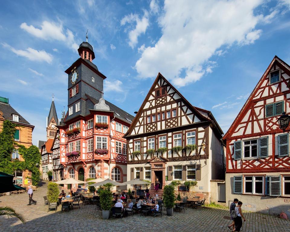ein altes Gebäude mit einem Uhrturm in einer Stadt in der Unterkunft Hotel Restaurant Goldener Engel in Heppenheim an der Bergstrasse