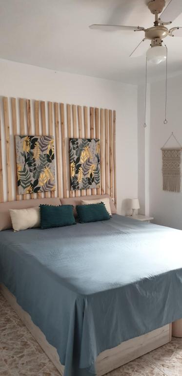 a bedroom with a large bed with blue sheets at Acogedor apartamento de playa in Puerto de Mazarrón