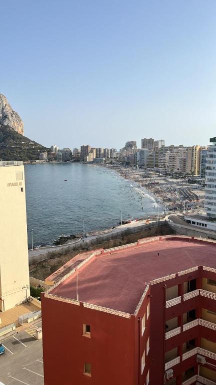 a view of a beach with a building and the water at Pequeno paraiso in Ifach
