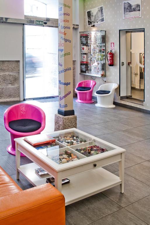 a room with pink chairs and a table in a store at JC Rooms Santo Domingo in Madrid