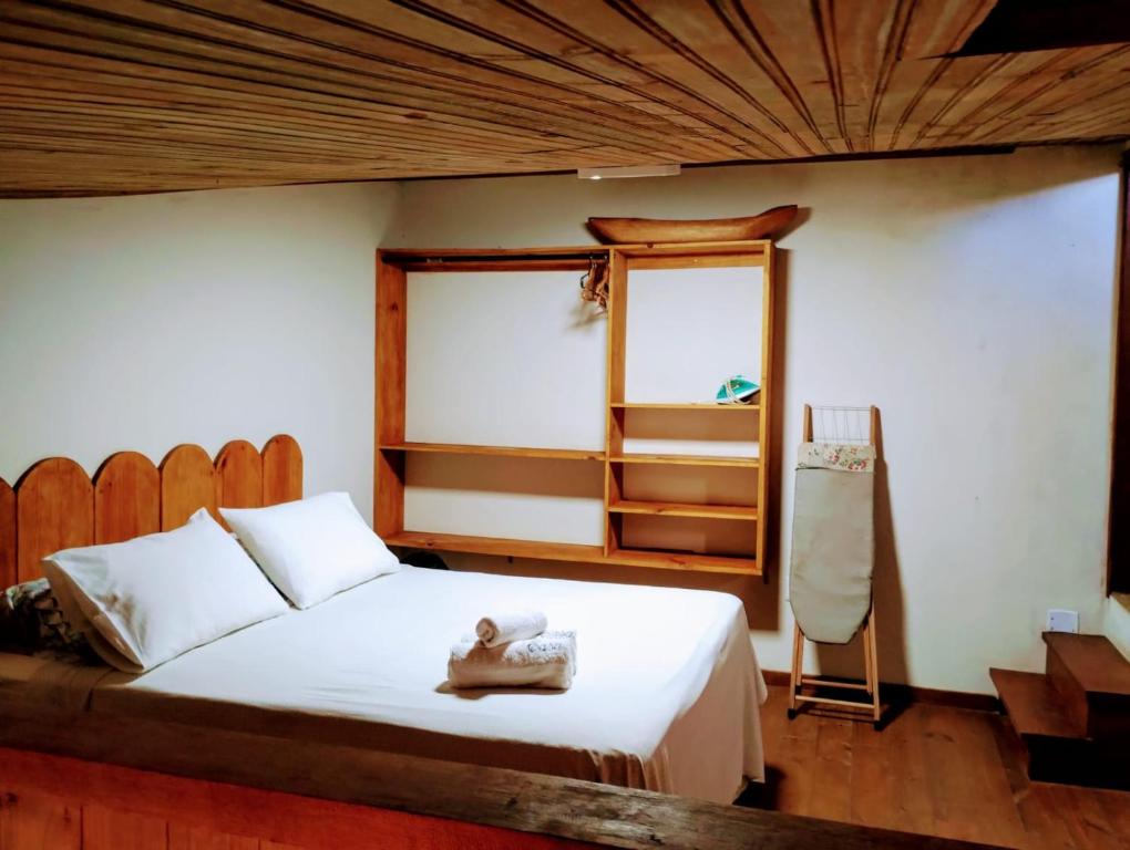 a bedroom with a white bed and a mirror at Casa Del Mar próximo as Praias in Itacaré