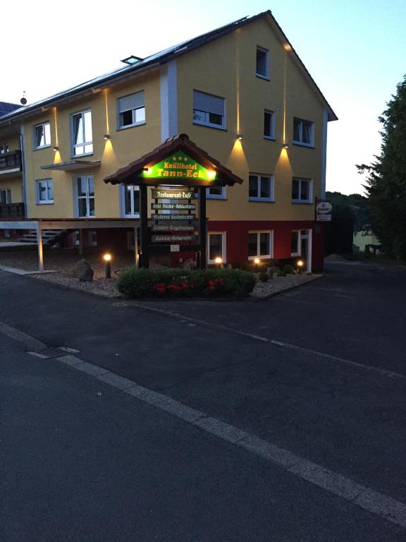 a building with a sign in a parking lot at Knüllhotel Tann-Eck in Knüllwald