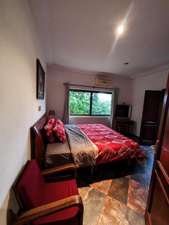 a bedroom with a large bed with a window at Luxor garden Apartment 1A in Accra