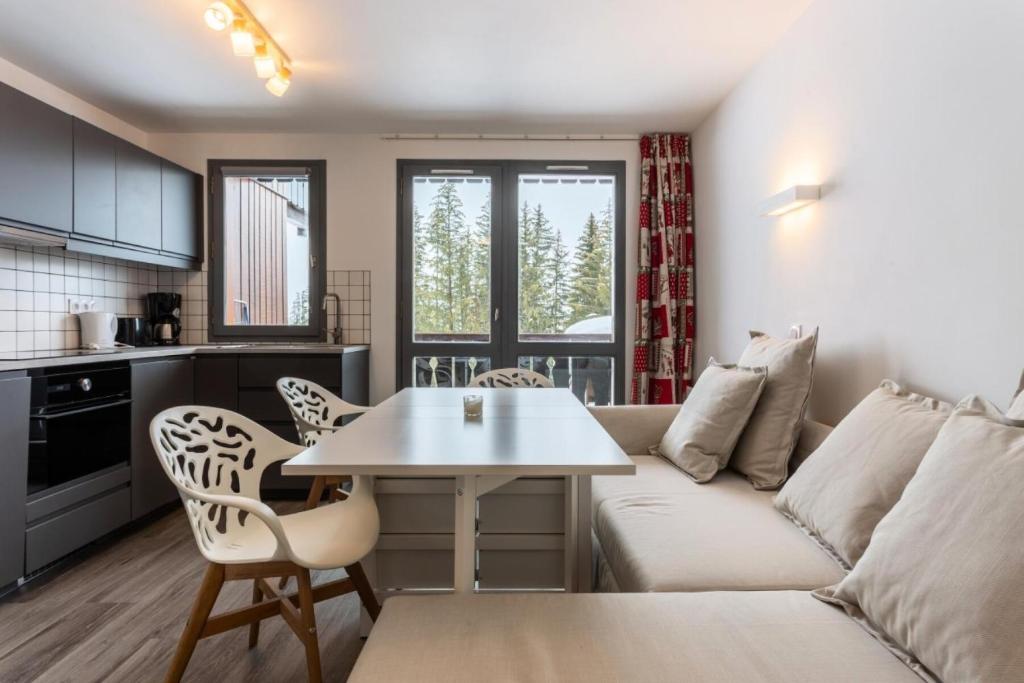 un salon avec un canapé et une table dans l'établissement Résidence Les Brigues - maeva Home - Appartement 2 Pièces 6 Personnes - Sélection MAE-4708, à Courchevel