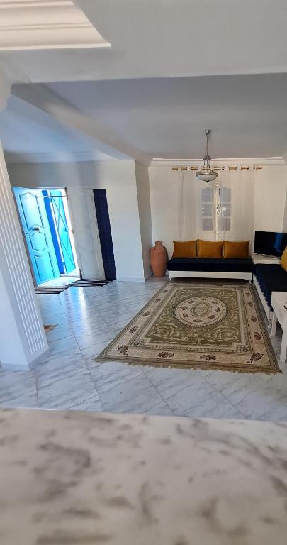 a living room with a couch and a rug at Maison d'été hessi Jerbi ras marmour in Zarzis